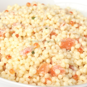 Un bol blanc rempli de Salade de Perles comprenant des pâtes au couscous, des morceaux d'orange saumon, des herbes visibles et un petit caviar rouge. Le logo "Cuisine Bernard" se trouve dans le coin supérieur droit.