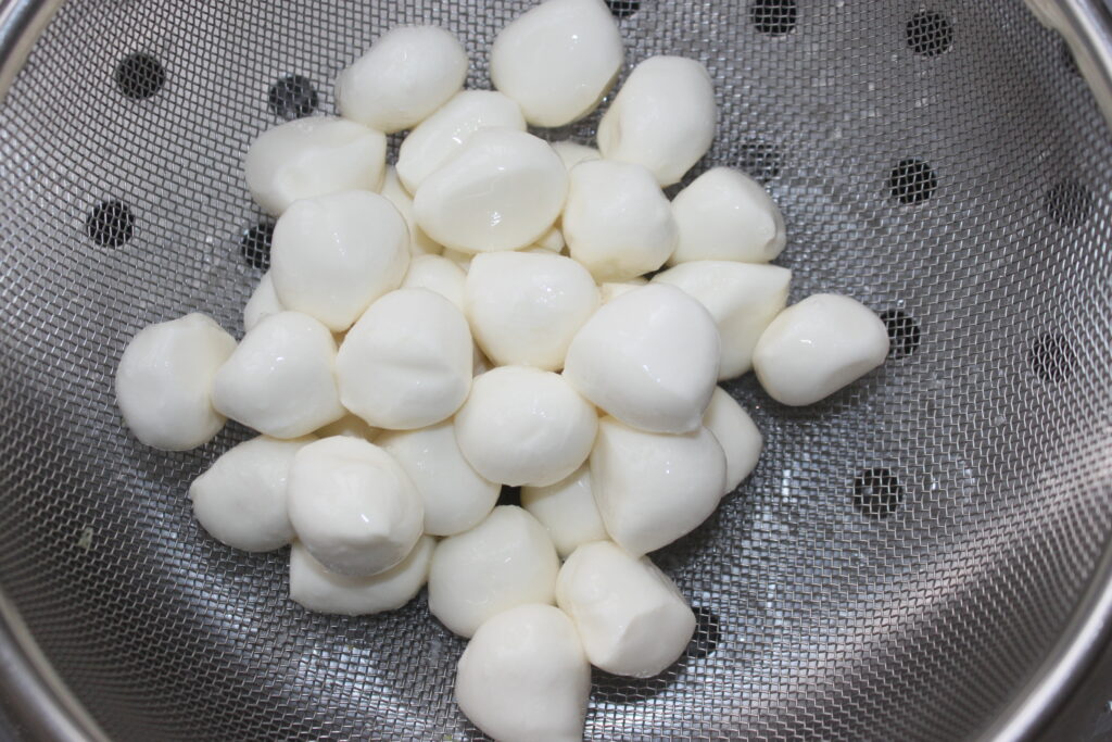 Une passoire remplie de petites boules de mozza rondes, parfaite pour accompagner la mayonnaise au wasabi.