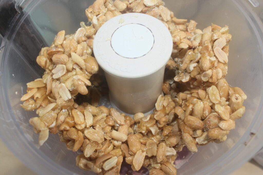 Un mélange d'avoine et de cacahuètes dans le bol d'un robot culinaire.