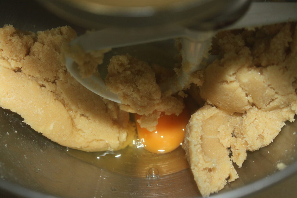 Un bol à mélanger rempli de pâte à biscuits, un œuf combiné à une pluie de mini M&M's pour des biscuits délicieusement colorés.