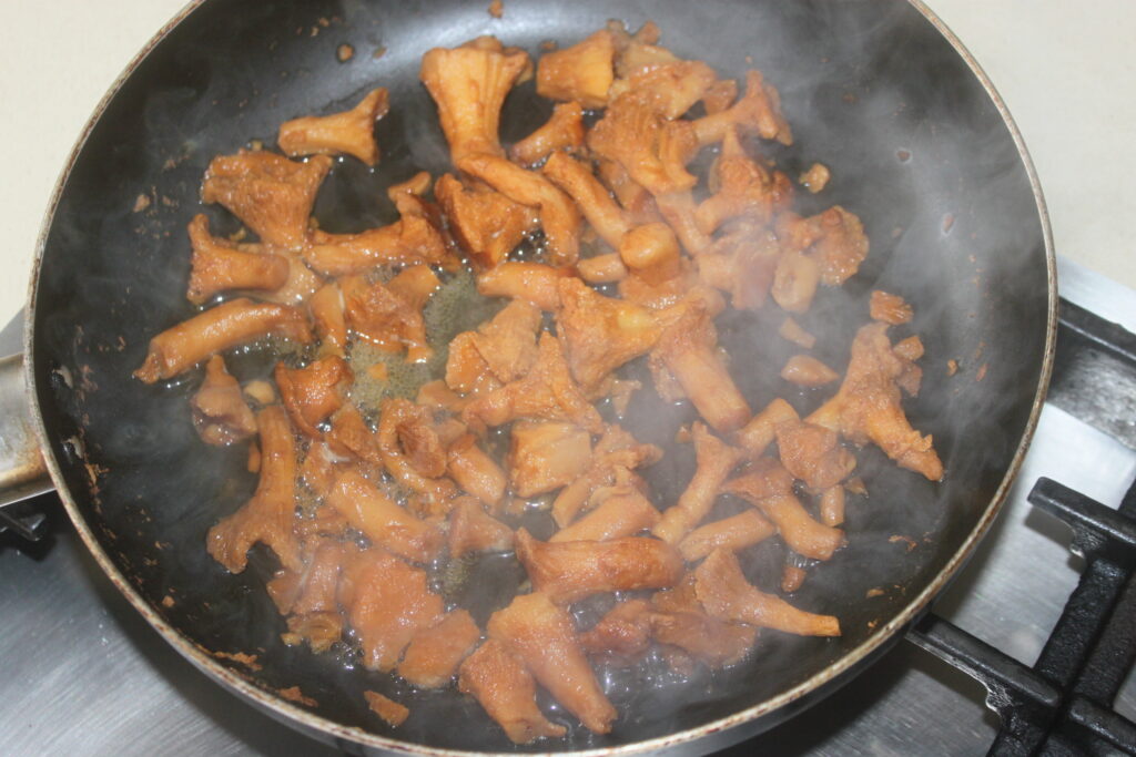 Chanterelles sautées à la poêle avec de la vapeur visible, parfaites pour accompagner une sauce gorgonzola ou pour compléter un magret fumé.