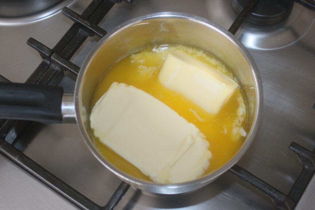 Une casserole sur une cuisinière contenant du beurre fondant, parfaite pour préparer des grecs traditionnels ou des baklava décadents.